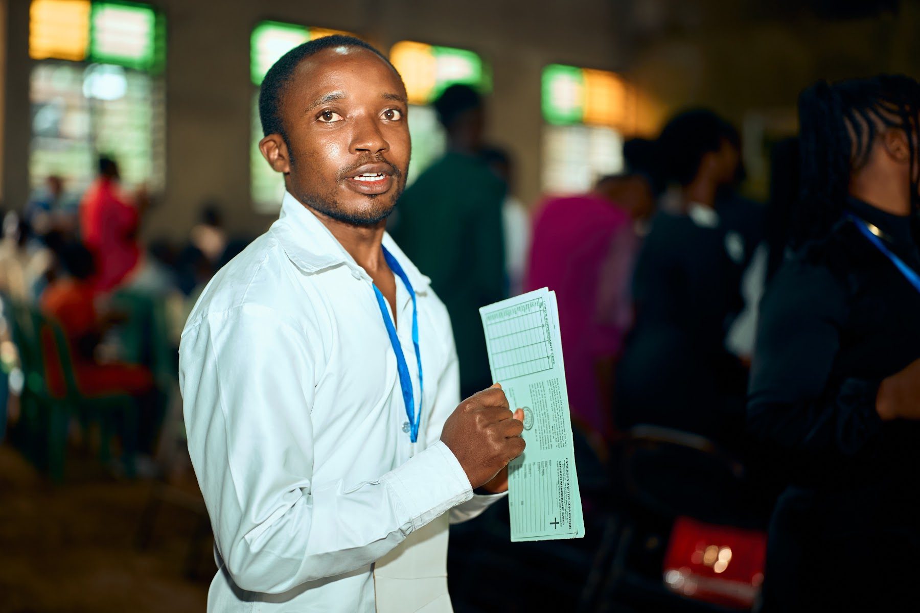An usher holding the order of service, ready to welcome guests